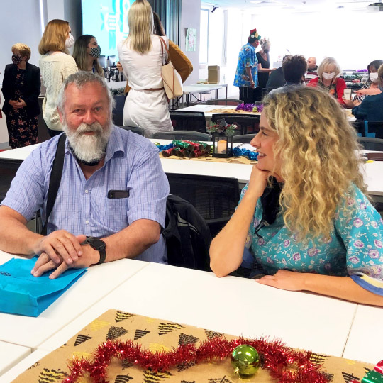 Brain Injury SA Christmas Party: Happy staff, participants and family members enjoying festive celebrations. Surrounded by Christmas decorations and yummy cake.
