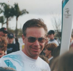 Photo of Colin holding the Olympics torch at sydney